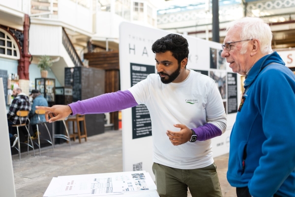  Two people talk through plans for Halifax town centre at an event in the Borough Market.