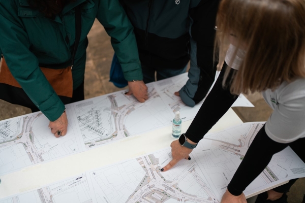 Three people discuss plans for changes to a road junction.